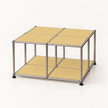 A modular metal storage cube with four beige panels on top and a lower shelf, supported by a stainless chrome frame with black feet, shown on a white background.