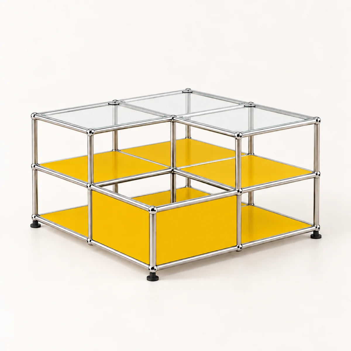 A modular storage organizer made of a chrome metal frame with clear glass panels on top and bright yellow shelves on the sides and bottom, shown on a light cream background.
