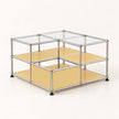 A modular metal cube storage organizer with clear glass top panels, light yellow shelves, and black feet, shown on a clean off-white background.