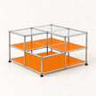 A modular two-tier storage cabinet with a chrome metal frame, clear glass top panels, and bright orange shelves and side panels, shown on a light beige background.