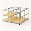 A modular cube storage organizer with a chrome metal frame, clear glass panels on the top, and light yellow shelves on the bottom, shown on a clean white background.