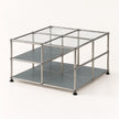 A modular metal and glass storage organizer with two gray shelves, clear glass top panels, and black feet, shown on a clean white background.