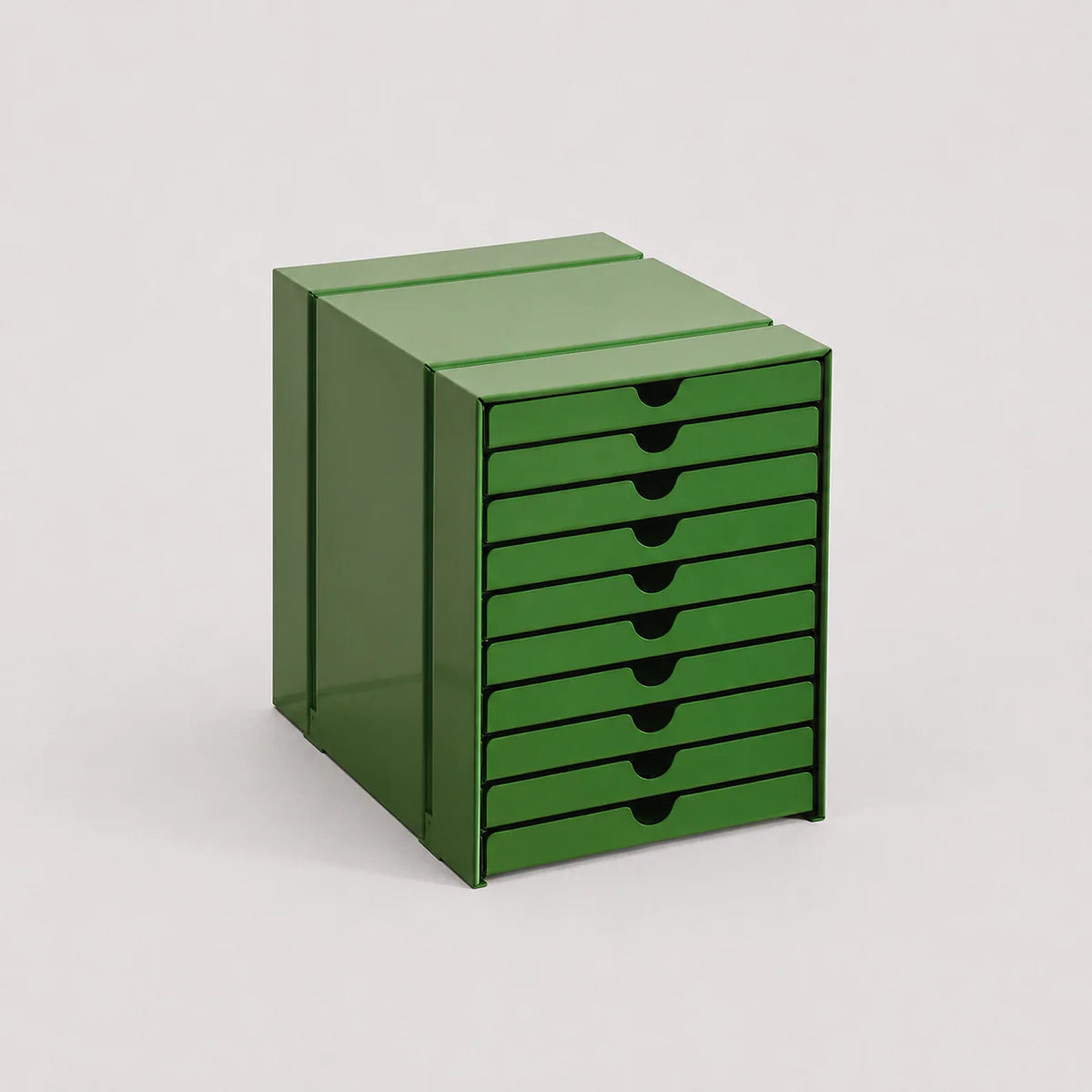 Green storage unit with multiple drawers on a light gray background