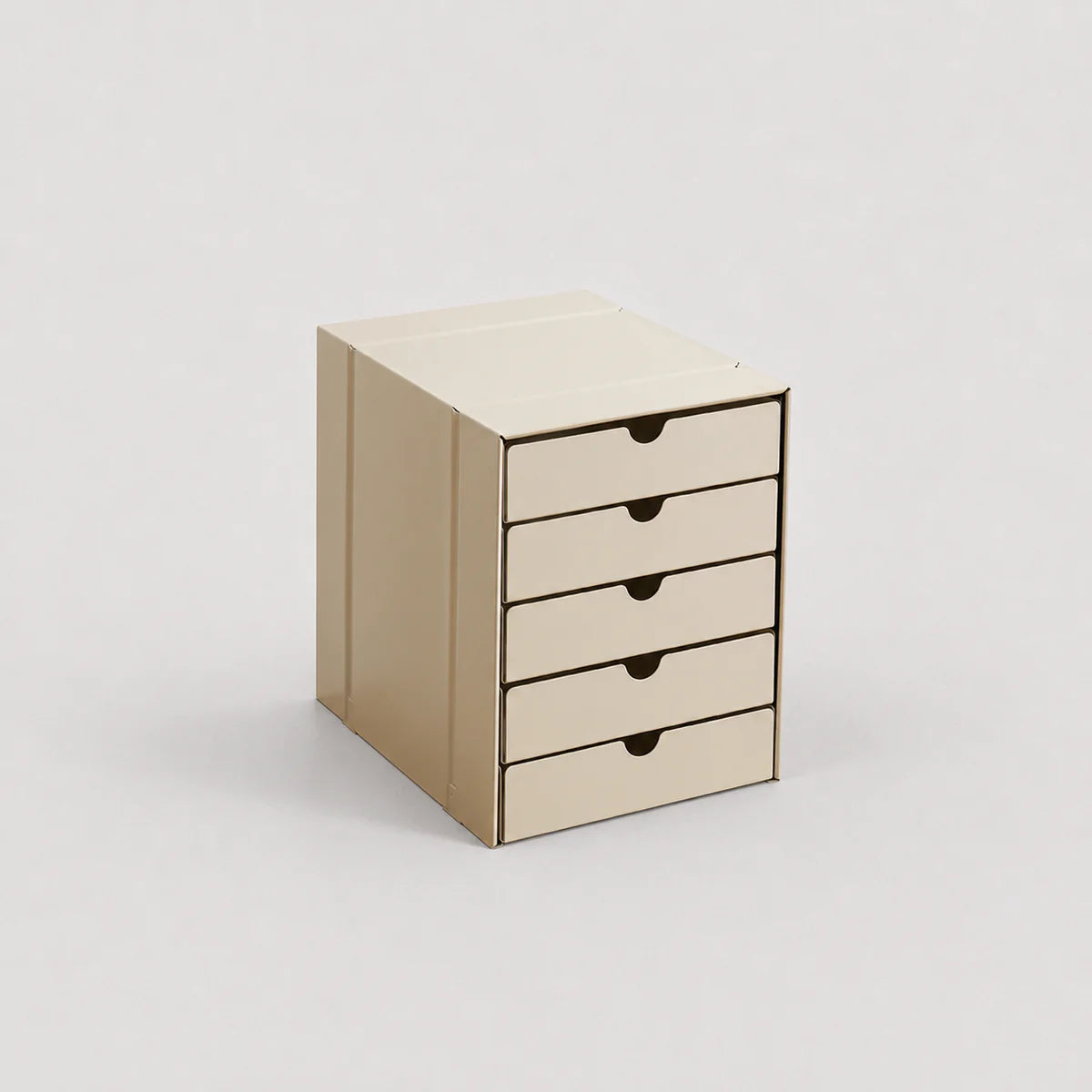 Beige cardboard storage box with four drawers on a light gray background