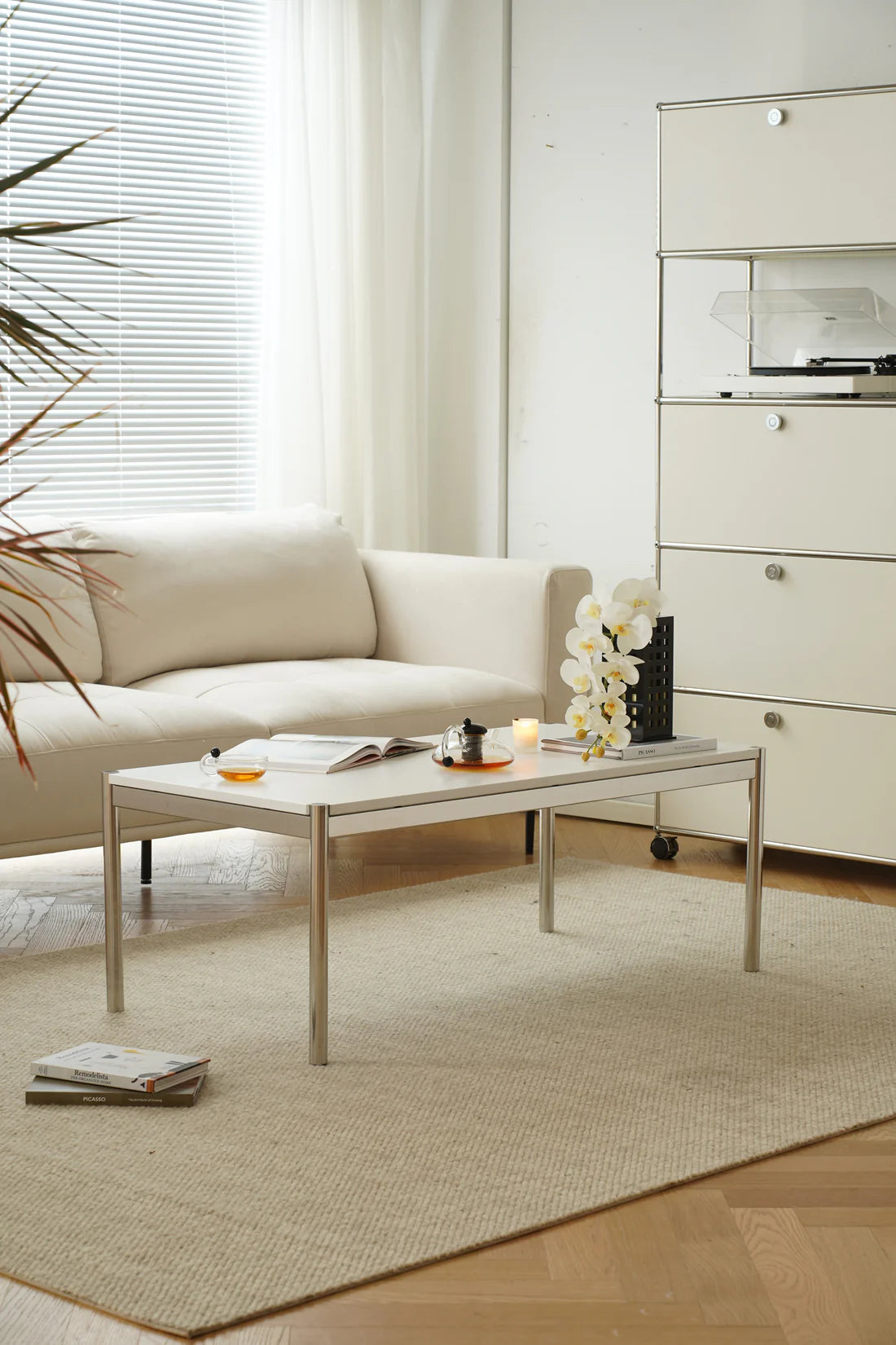 Modern living room with a beige sofa, replica USM modular coffee table, and decorative elements.