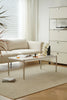 Modern living room with a beige sofa, replica USM modular coffee table, and decorative elements.