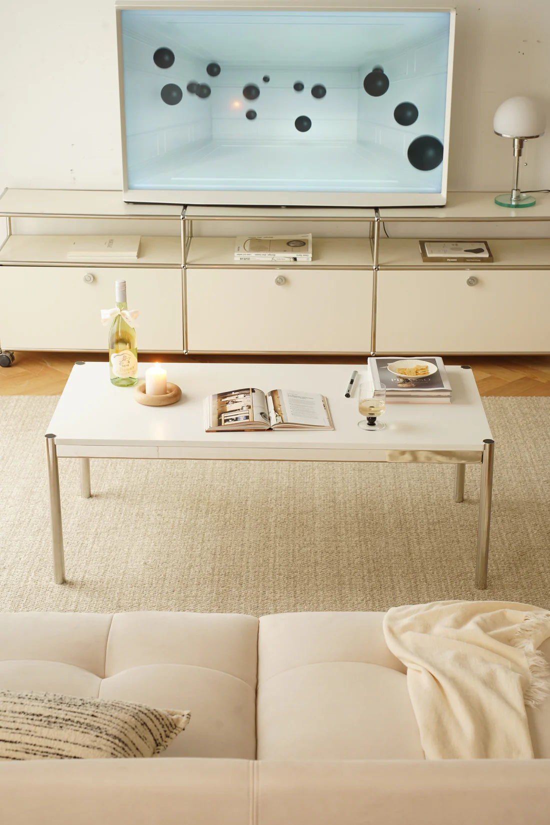 Modern living room with a flat-screen TV, replica USM modular coffee table, and sofa.