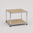 A two-tier modular storage shelf with a chrome metal frame, beige metal-covered shelves, and black caster feet, shown on a light gray background.