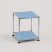 A modern two-tier modular side table with a chrome metal frame and light blue panel shelves, shown on a neutral light gray background.