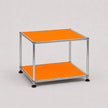 A two-tier modular side table featuring orange shelves and a chrome metal frame with black feet, photographed on a neutral light gray background.