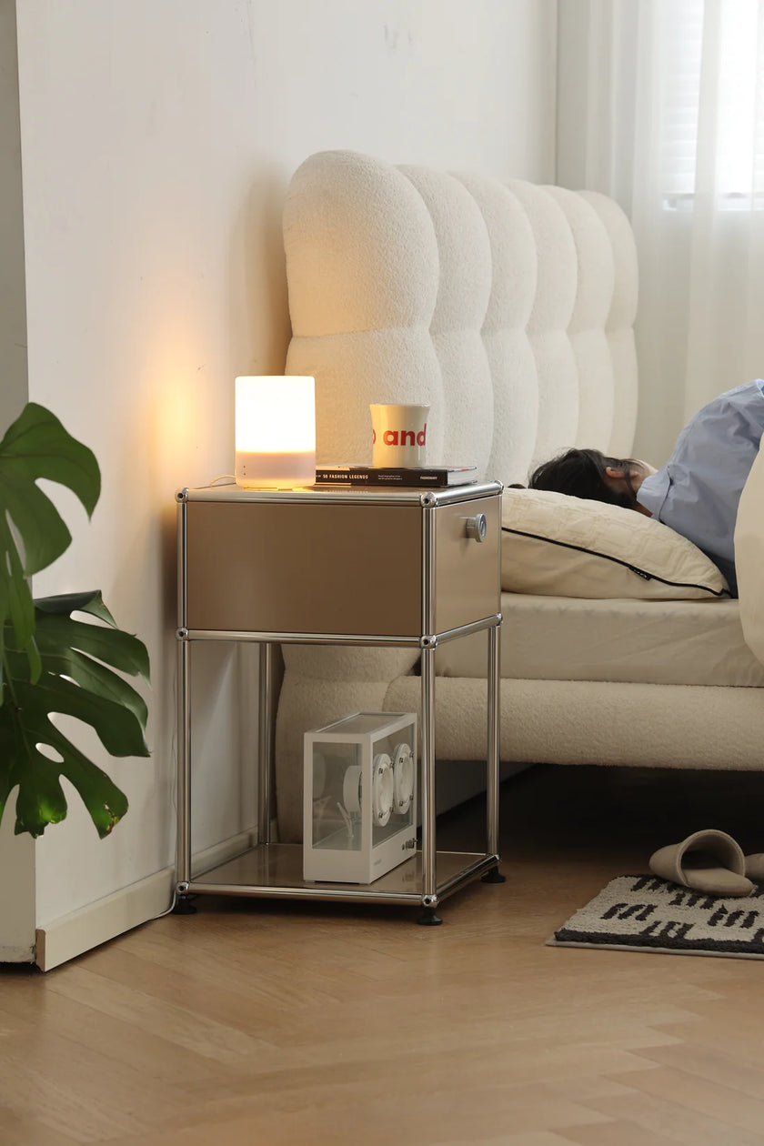 Modern bedroom with a inspired recreation USM modular nightstand, lamp, and lady lying in bed.