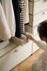 Lady organizing clothes in a replica USM modular wardrobe with a basket.