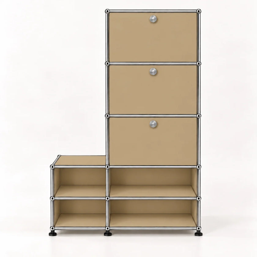 A modular storage organizer with three tall drawers on the right and four open shelfs on the bottom, made from beige metal panels with a chrome metal frame and round silver knobs.