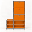 An L-shaped modular storage unit with bright orange panels and a chrome metal frame, featuring three drawers on the upper right with round silver knobs and four open shelves on the lower, set against a plain white background.