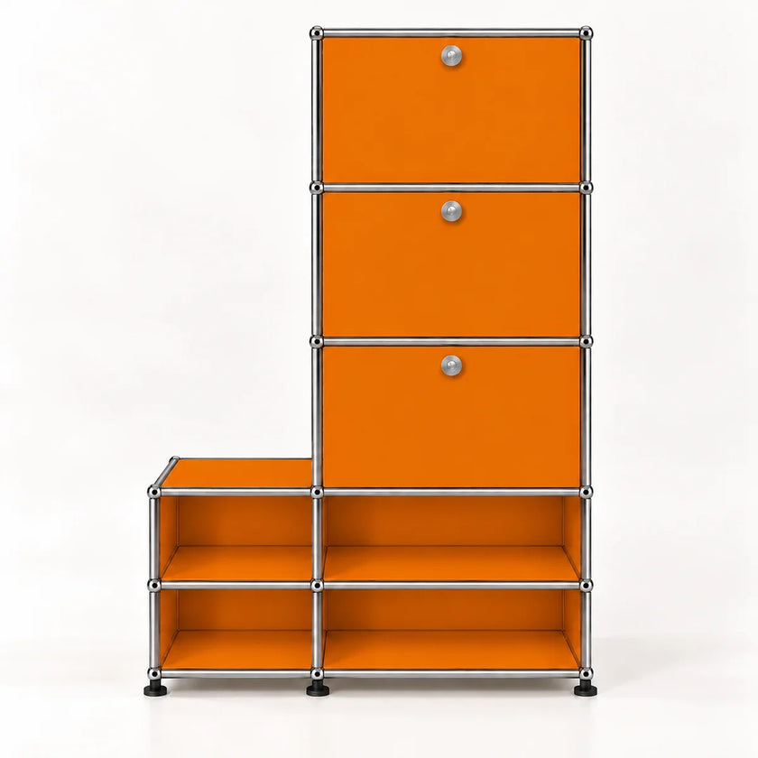 An L-shaped modular storage unit with bright orange panels and a chrome metal frame, featuring three drawers on the upper right with round silver knobs and four open shelves on the lower, set against a plain white background.
