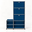 A modular storage cabinet with blue metal drawer fronts and open shelves, connected by a chrome metal frame with small round silver knobs.
