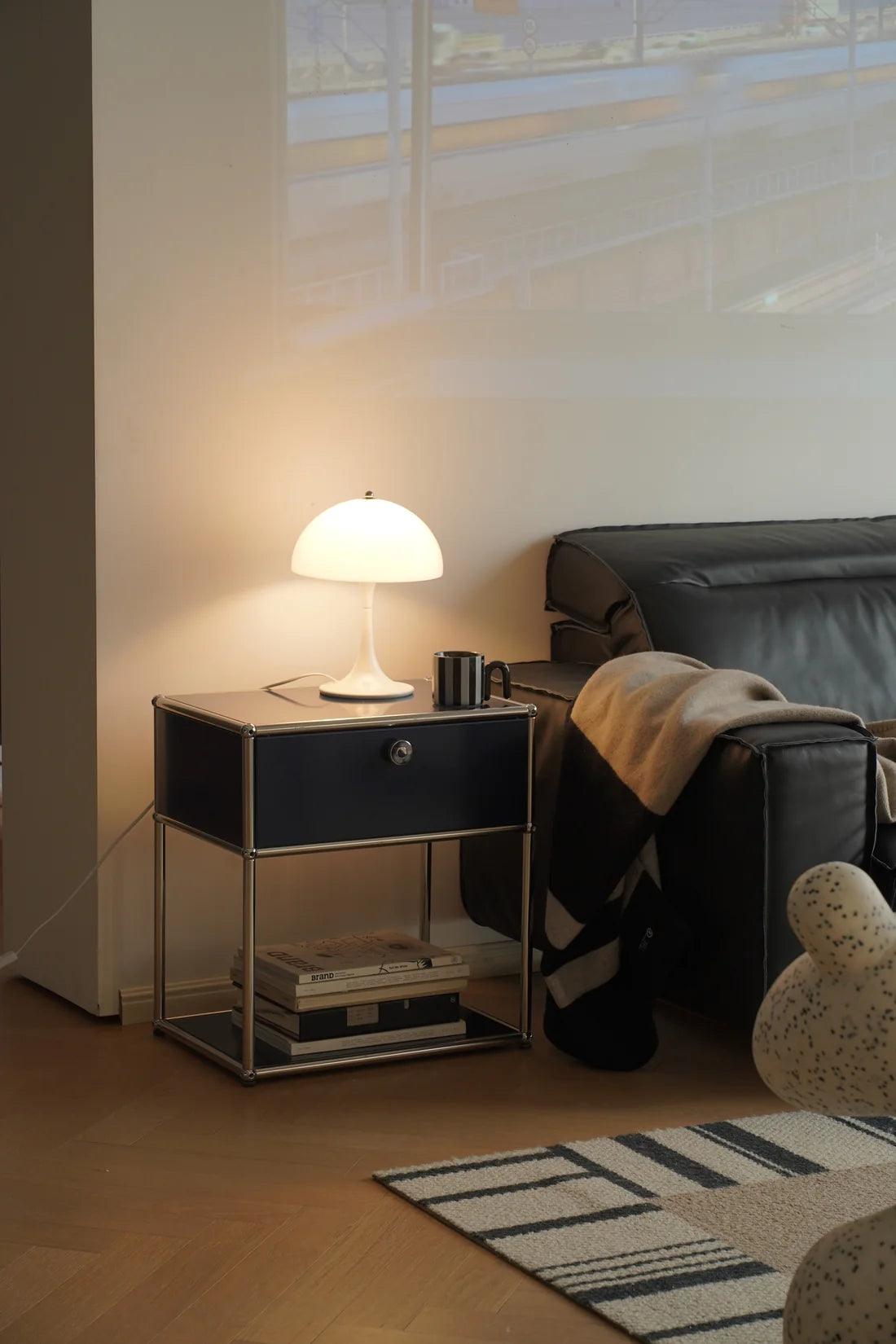 Modern living room with a replica USM modular side table, lamp, and sofa.