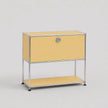 A modern modular two-tier storage cabinet with a pale yellow enamel finish and a chrome-plated tubular steel frame, featuring a single lock on the upper drawer front.