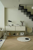 Modern interior with a staircase, white replica USM modular console side table, and decorative items.