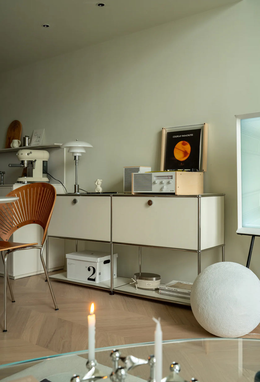 Modern interior with a sideboard, chair, and decorative items.