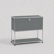 A modern gray modular storage cabinet with a single lockable door and an open lower shelf, supported by a slim chrome metal frame, shown against a light gray background.
