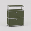 An olive green modular storage cabinet with two drawers and an open top shelf, framed in polished chrome metal with round silver knobs, on a light gray background.