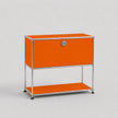 An orange modular storage cabinet with a silver metal frame, featuring a single lockable door with a round silver handle and an open lower shelf, set against a light gray background.