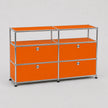 An orange modular storage cabinet with a chrome metal frame and four drawers, set against a neutral gray background.