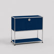 A modern modular two-tier storage cabinet with a dark blue fabric front, a silver chrome metal frame, and a small round silver lock on the upper door, set against a light gray background.