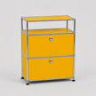 A modern two-drawer modular storage cabinet with a bright yellow enamel finish and a chrome tubular metal frame, featuring small round silver knobs and black caster wheels.
