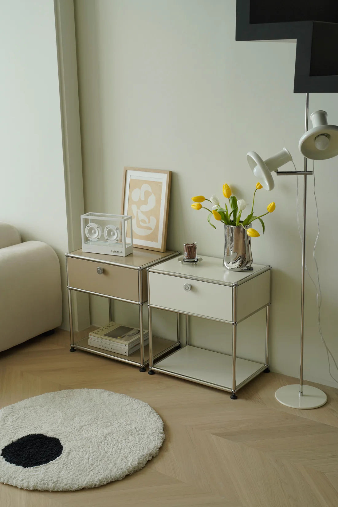 Modern living room with replica USM modular side tables, a lamp, and decorative items.