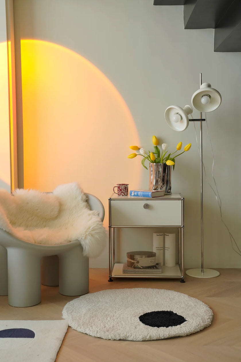 Modern interior with a chair, inspired recreation USM modular side table, and floor lamp.