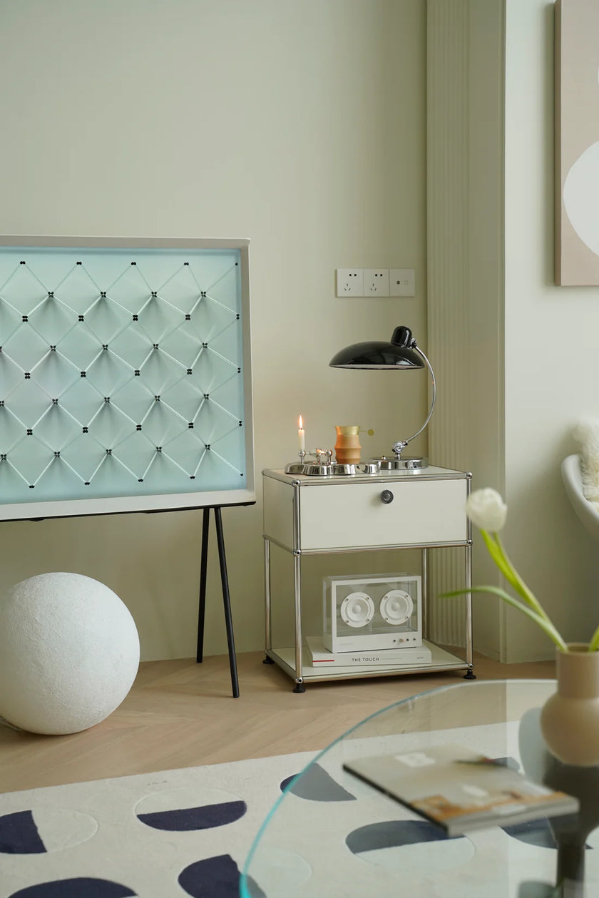 Modern interior with a inspired recreation USM modular side table, lamp, and decorative items on a light green wall.