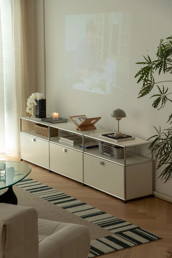Modern living room with a white replica USM tv stand, sofa, and decorative items.