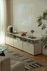 Modern living room with a white replica USM tv stand, sofa, and decorative items.