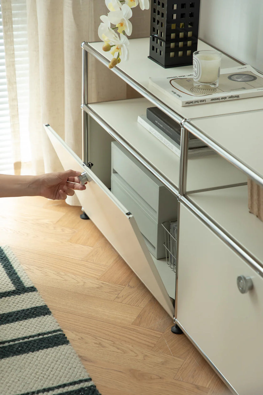 Person opening a inspired recreation USM tvstand cabinet door to reveal storage space underneath.