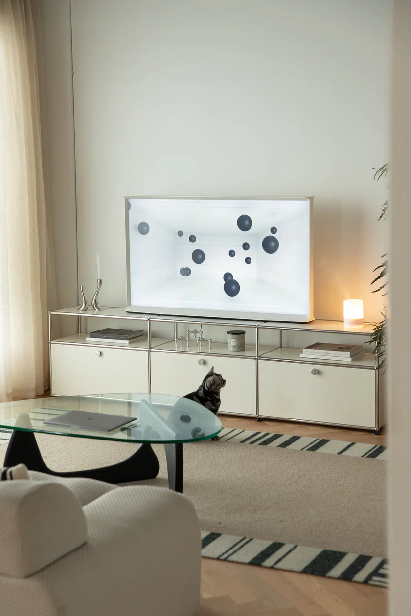 Modern living room with a television on a white inspired recreation USM modular furniture entertainment console.