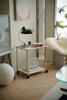 Small metal replica USM modular cart with a lamp and books in a modern room setting