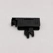 A small black plastic component with molded ridges and a tab-like protrusion, photographed on a plain light gray background.