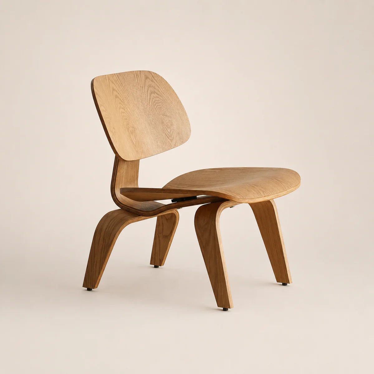 A mid-century modern wooden chair with a curved plywood seat, backrest, and legs, shown on a plain beige studio background.