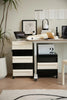 Modern office desk with black and white design storage units, plants, and decor.