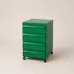Green abs plastic file cabinet with multiple drawers on a beige background