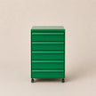 Green abs plastic drawer unit on wheels against a beige background