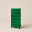 Green abs plastic filing cabinet on a beige background