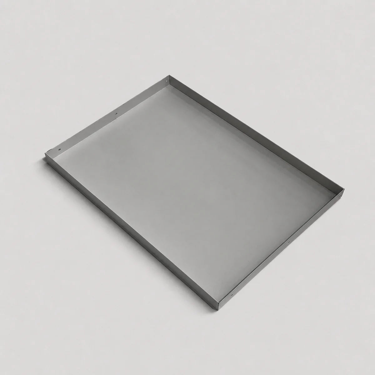 A minimalist rectangular metal tray with a thin silver frame, shown at an angle on a light gray background.