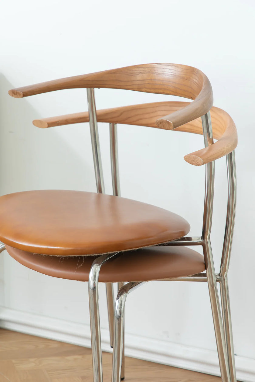 Wooden dining room chair with metal frame against a white wall
