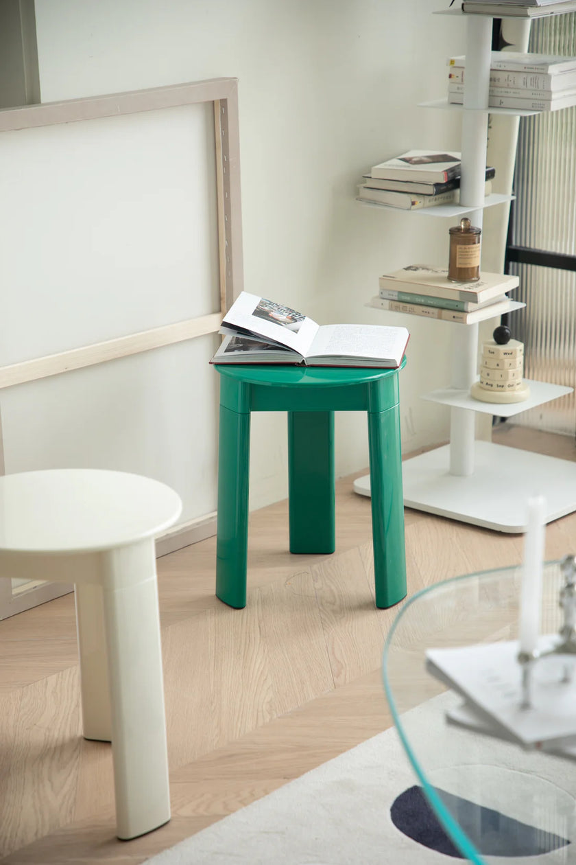 Green stool with an open book in a modern room setting