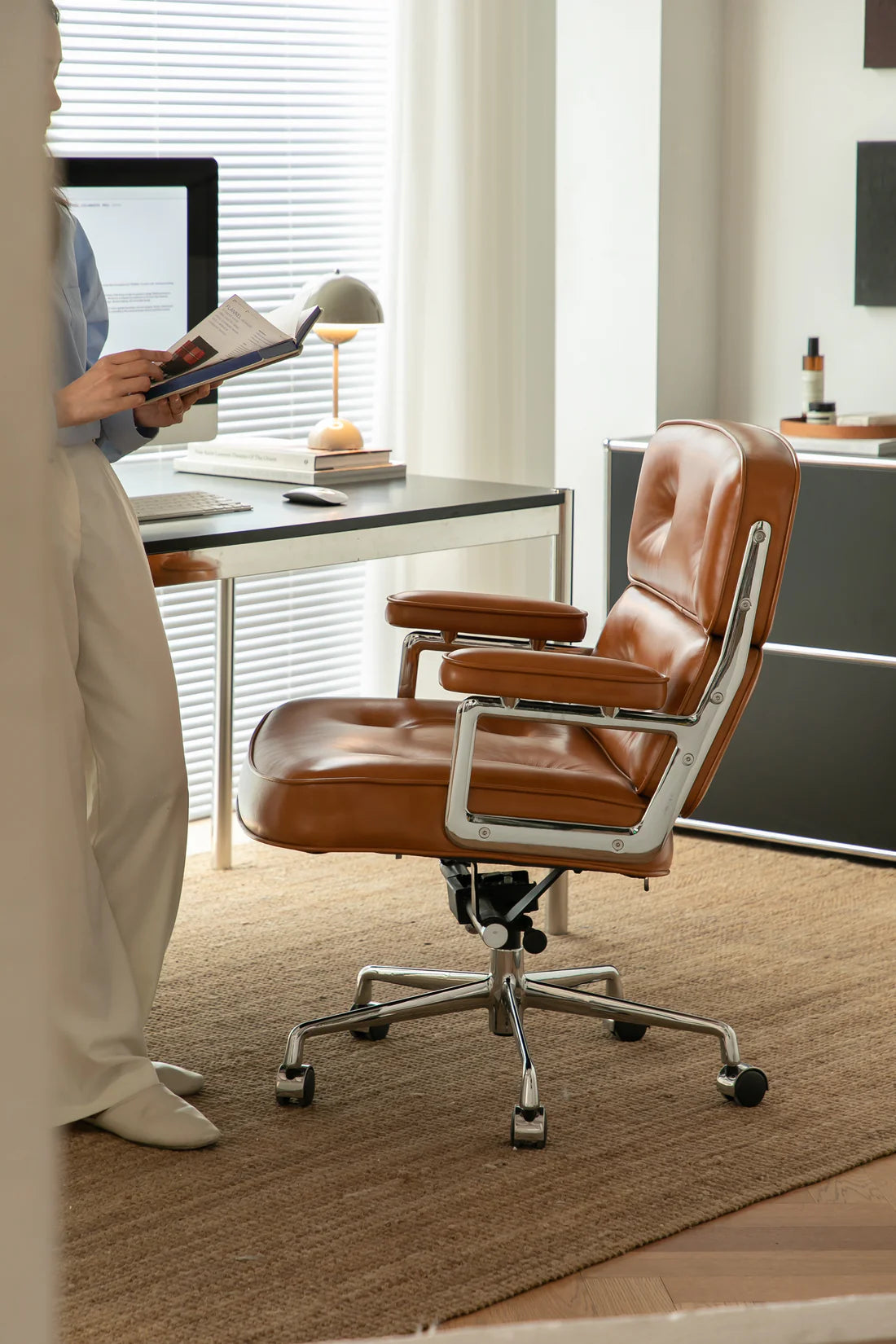 Brown office swivel chair in a modern office setting with a desk and computer.