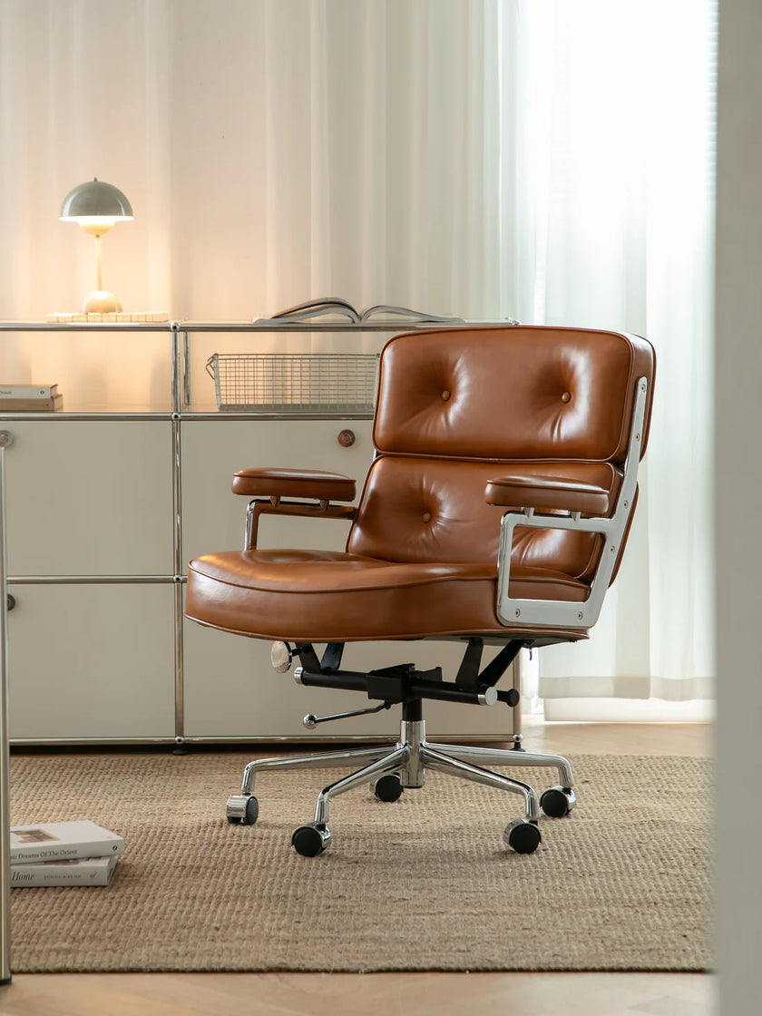 Brown leather office chair in a modern office setting with a glass partition.