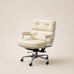 Cream-colored office chair with a metallic frame on a beige background